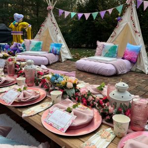 Outdoor picnic setup with Enchanted Garden theme teepees
